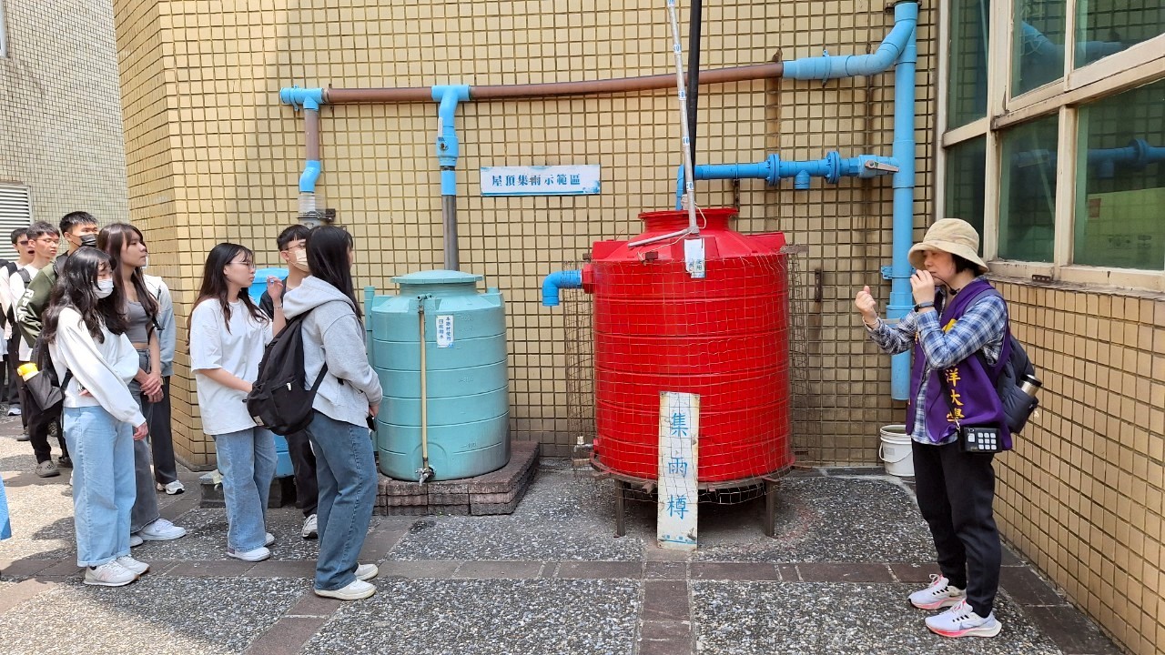 學生們仔細聆聽環保志工解說屋頂集雨示範區的運作模式