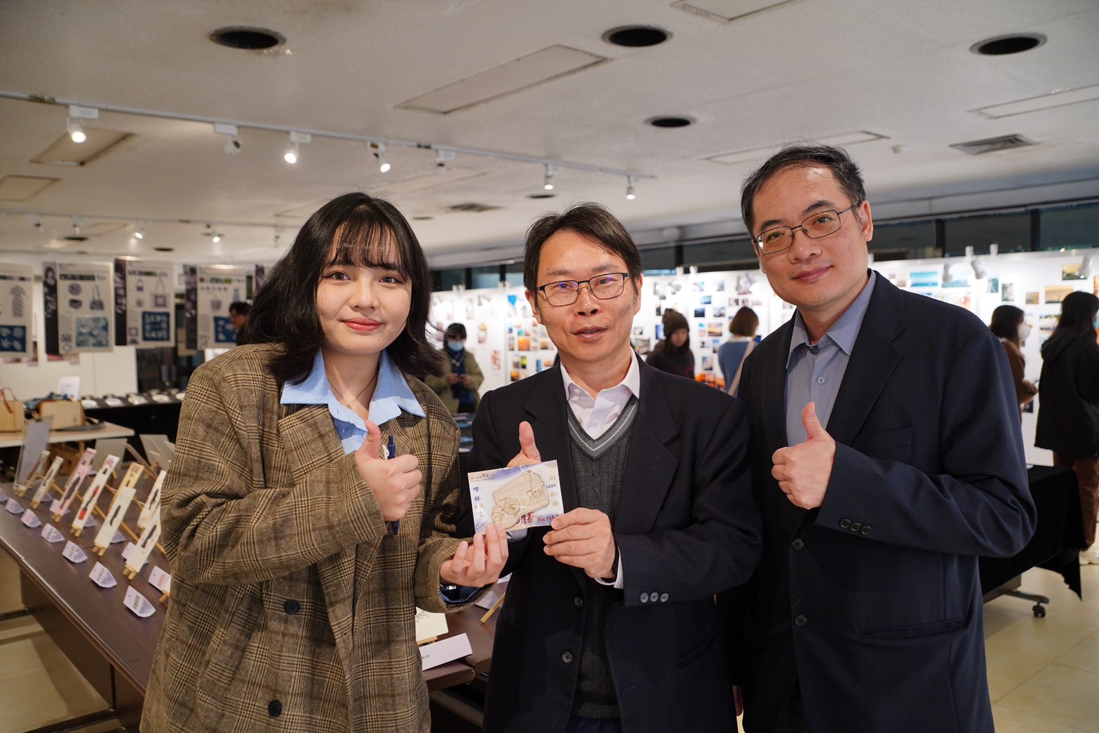 海大李明安副校長(中)稱讚本次展覽的紀念品設計
