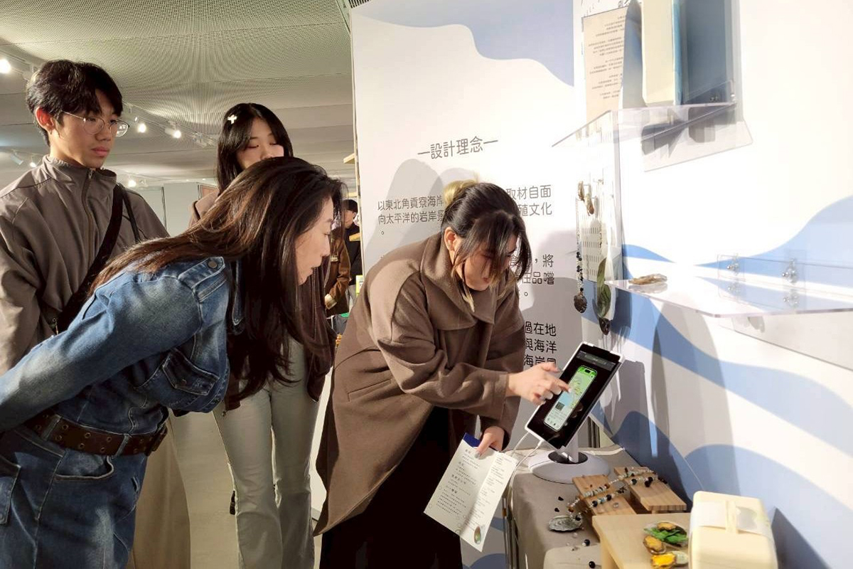 江亭玫局長悉心聆聽各專題製作的導覽說明，圖為以貢寮鮑為主題的專題「殼息」。