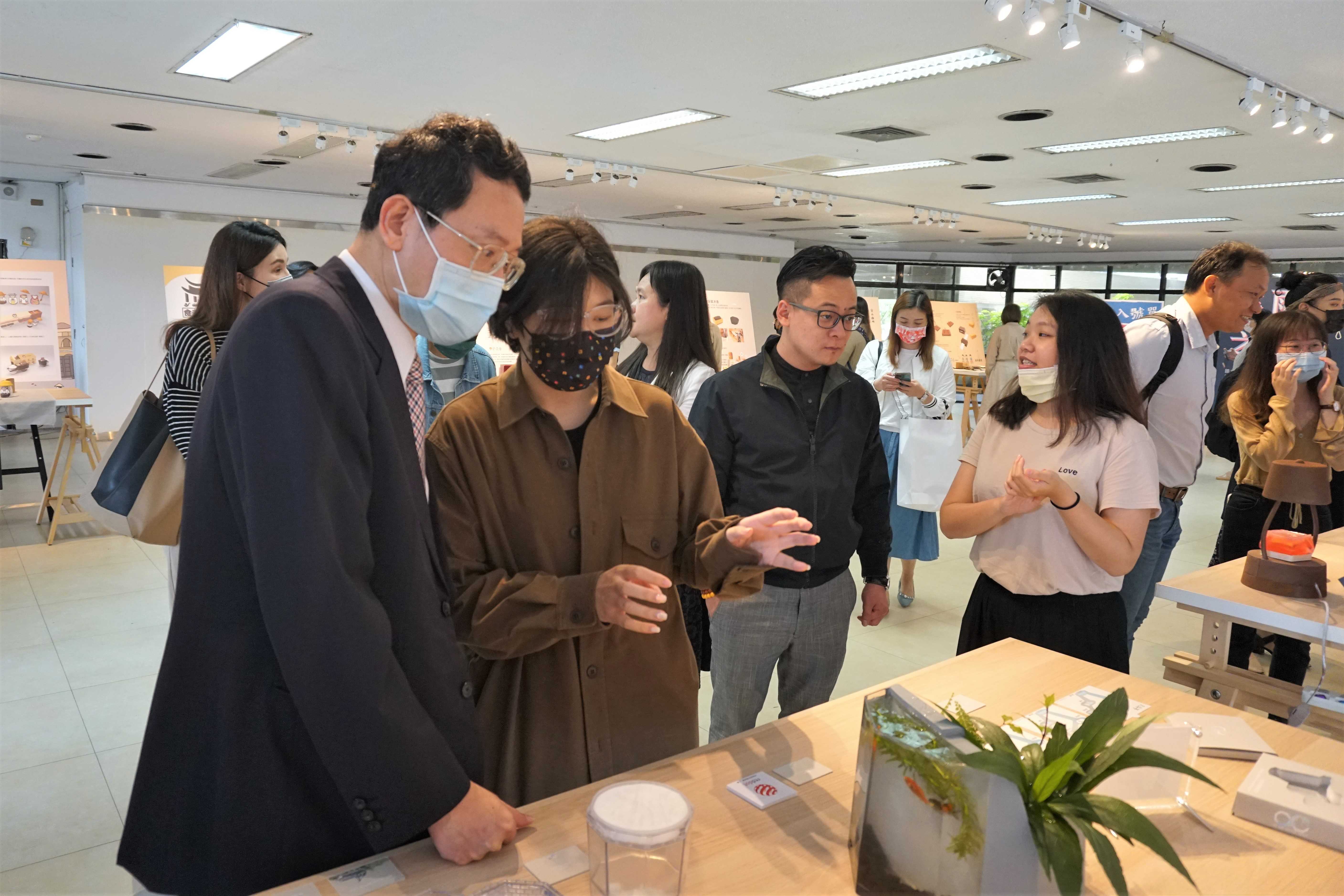 學生為莊季高副校長及童子瑋議員解說今年入圍德國紅點的作品0-compressed