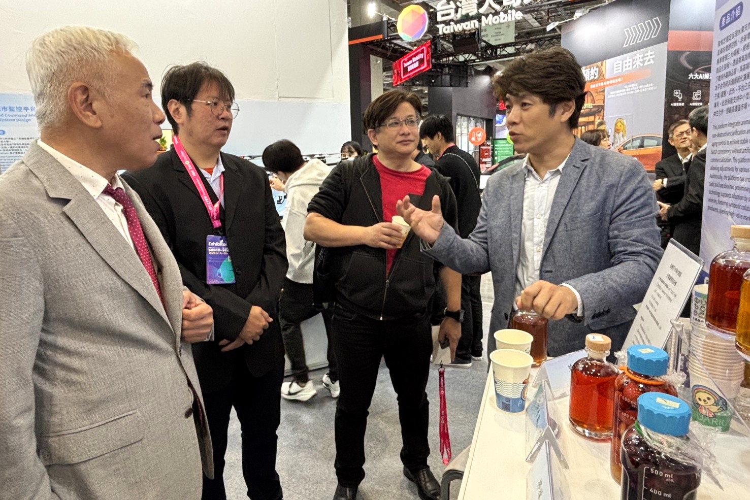 食科系陳建利助理教授(右)說明其建構的「天然香氣導向果實發酵與後熟風味精準控制技術平台」。(左1為曉鹿鳴樓曾隱舜董事長)