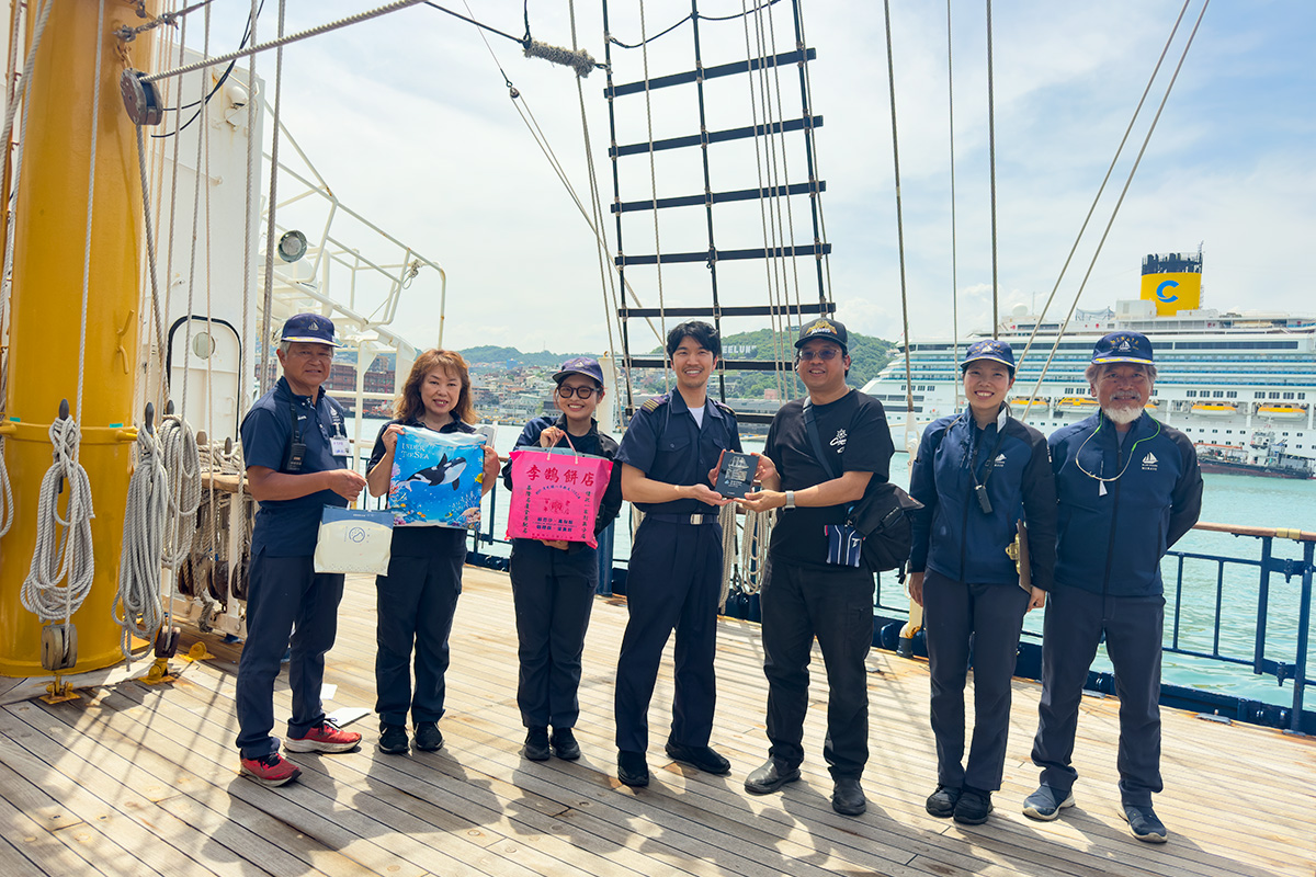 海大師資培育中心教授兼共同教育中心主任張正杰(右3)與日本練習帆船 BLUE OCEAN みらいへ的船員交換紀念品。